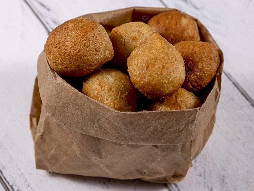 Salgados e ketchup em uma cesta com papel sobre mesa branca isolada