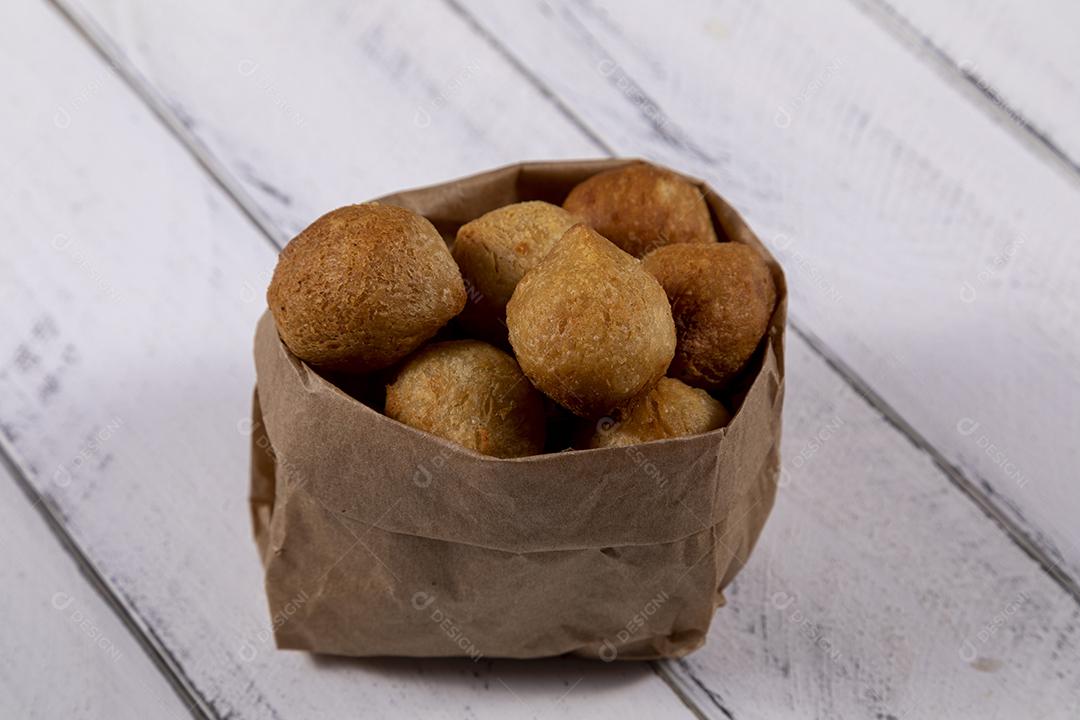 Salgados e ketchup em uma cesta com papel sobre mesa branca isolada