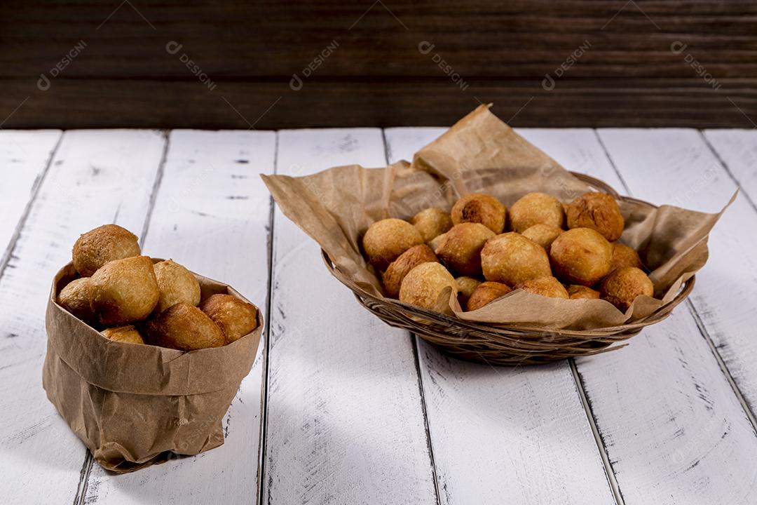 Salgados e ketchup em uma cesta com papel sobre mesa branca isolada