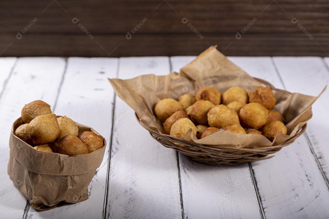 Salgados e ketchup em uma cesta com papel sobre mesa branca isolada