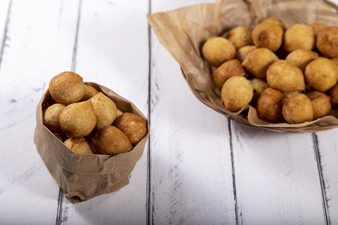 Salgados e ketchup em uma cesta com papel sobre mesa branca isolada