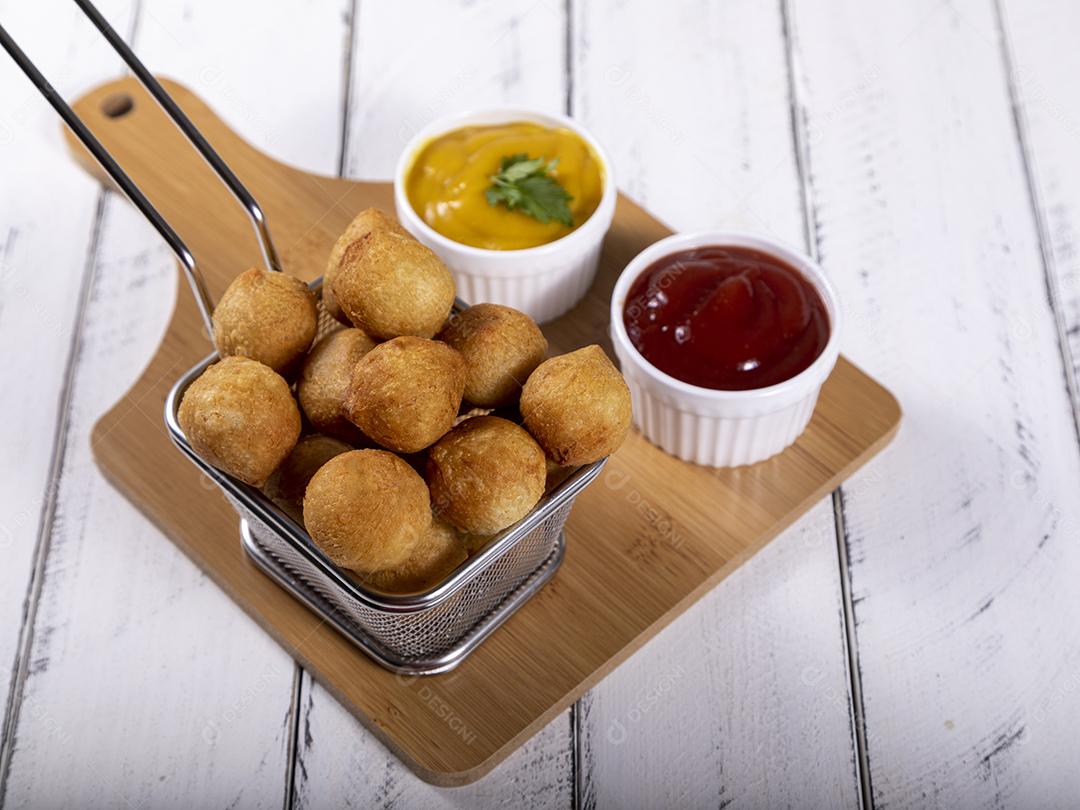 Salgados de frango fritos em tigela grade sobre fundo branco