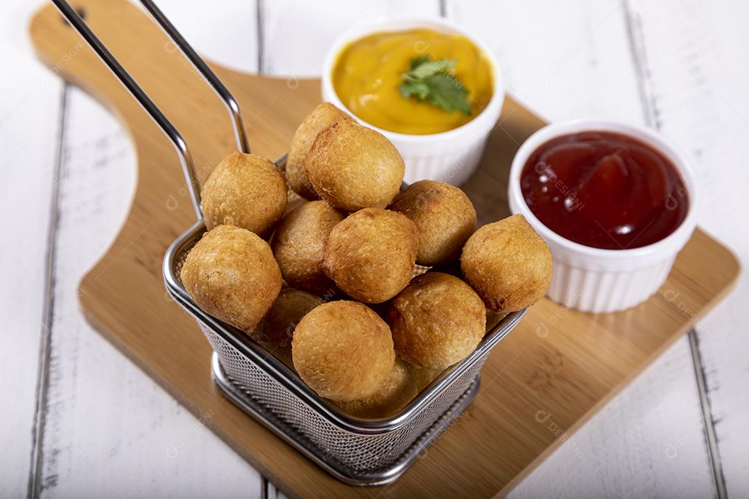 Salgados de frango fritos em tigela grade sobre fundo branco