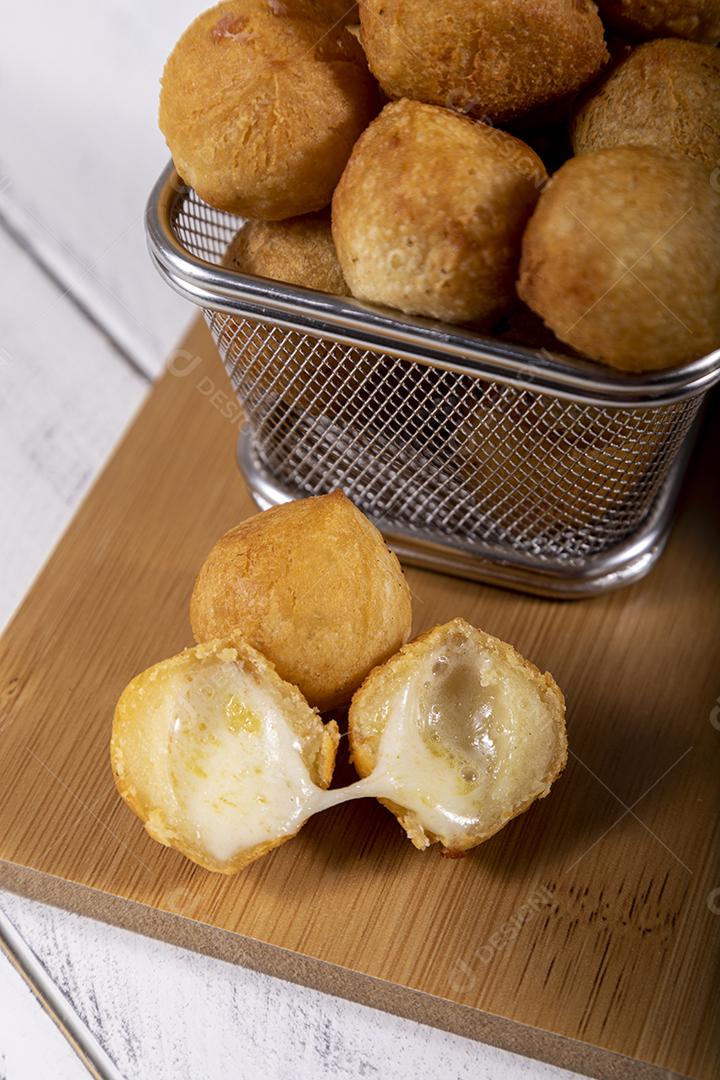 Salgados de queijo fritos em tigela grade sobre fundo branco