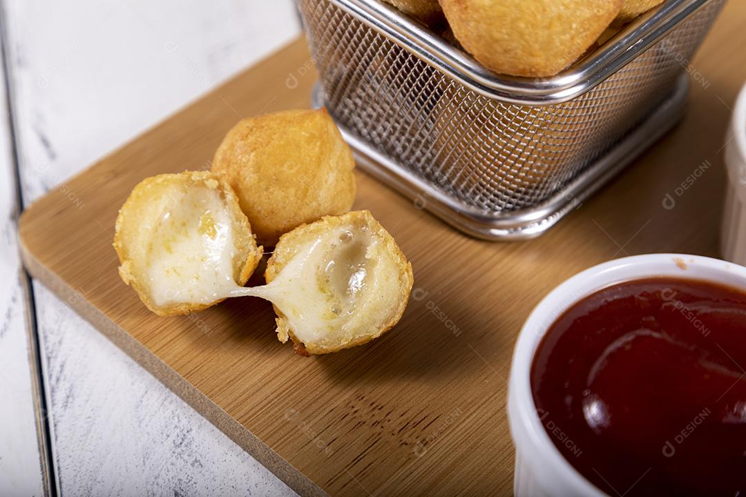 Salgados de queijo fritos em tigela grade sobre fundo branco