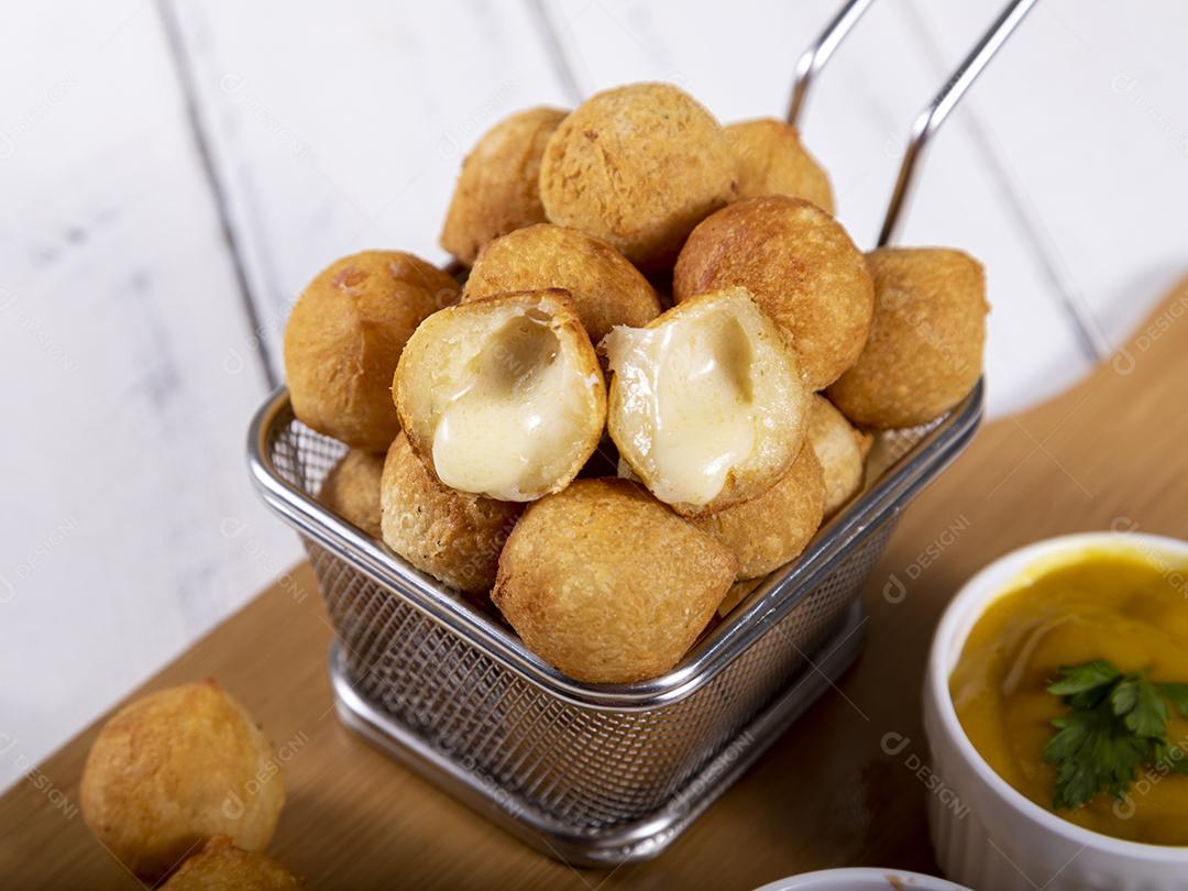 Salgados de queijo  fritos em tigela grade sobre fundo branco