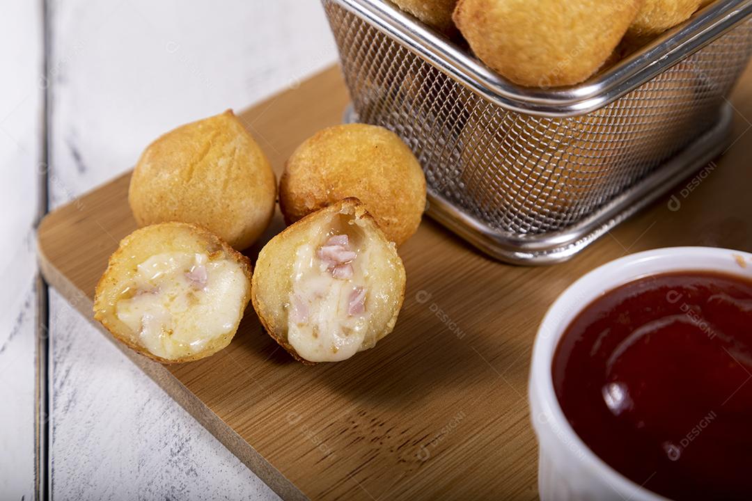 Salgados de frango fritos em tigela grade sobre fundo branco