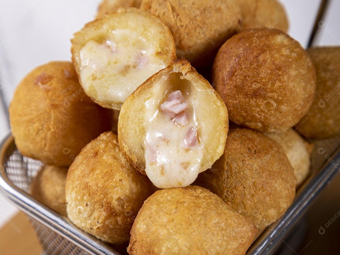 Salgados de frango fritos em tigela grade sobre fundo branco