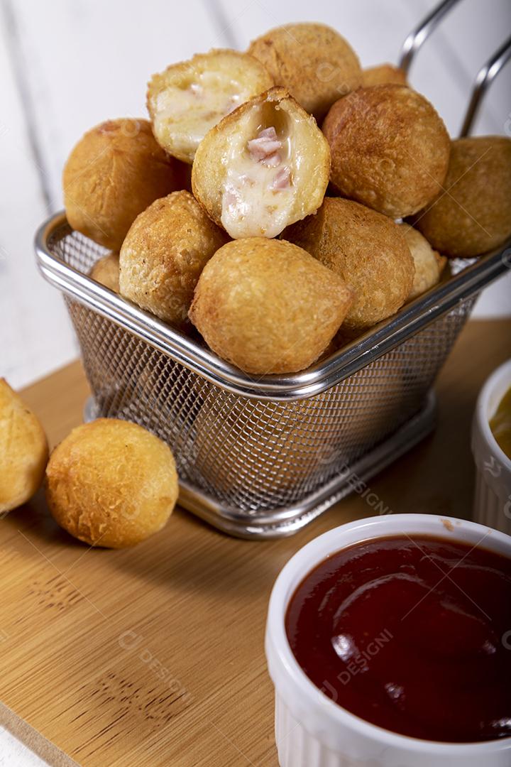 Salgados de frango fritos em tigela grade sobre fundo branco