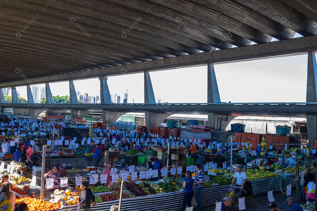 Pessoas no meio do galpão feira vendas frutas e verduras