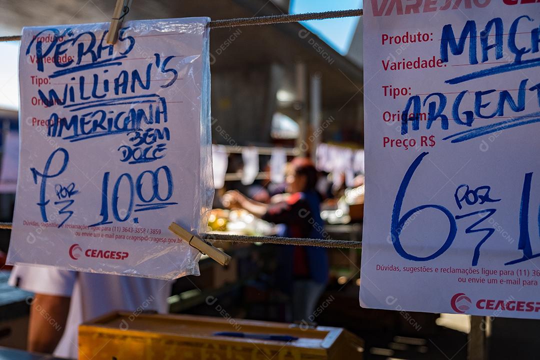 Pessoas no meio do galpão feira vendas frutas e verduras