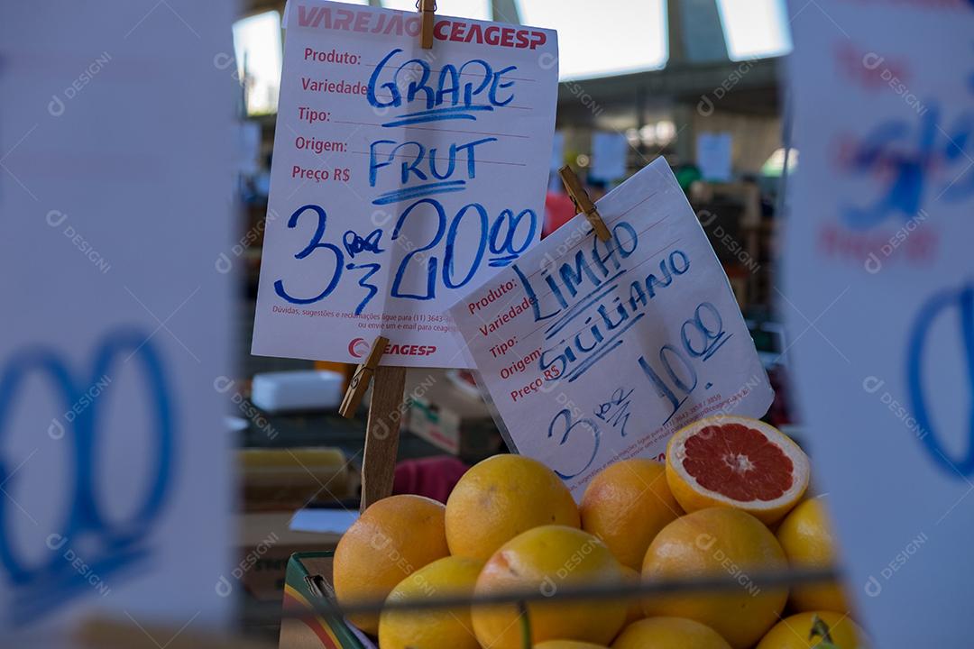 Pessoas no meio do galpão feira vendas frutas e verduras