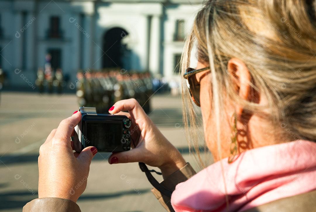 Mulher jovem loira segurando câmera fotografica