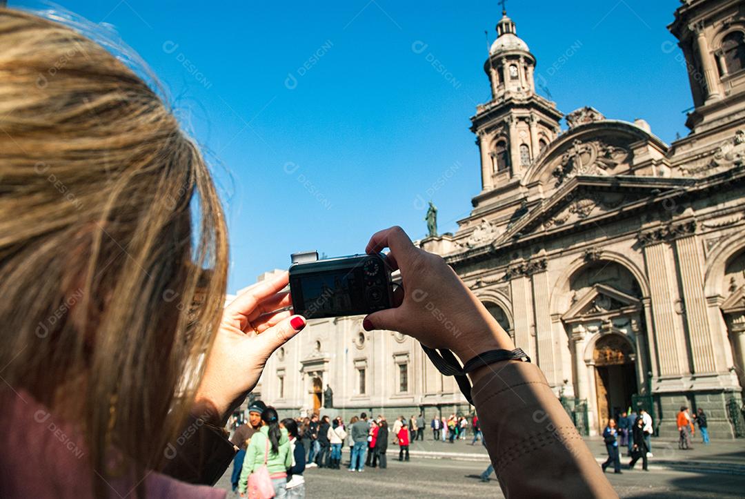 Mulher jovem loira segurando câmera fotografica