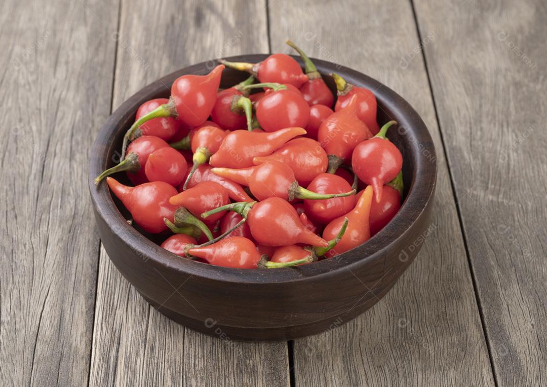 Biquinho de pimenta vermelha em uma tigela sobre a mesa de madeira