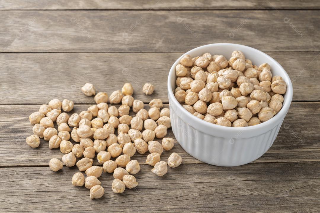 Grão de bico em uma tigela sobre a mesa de madeira