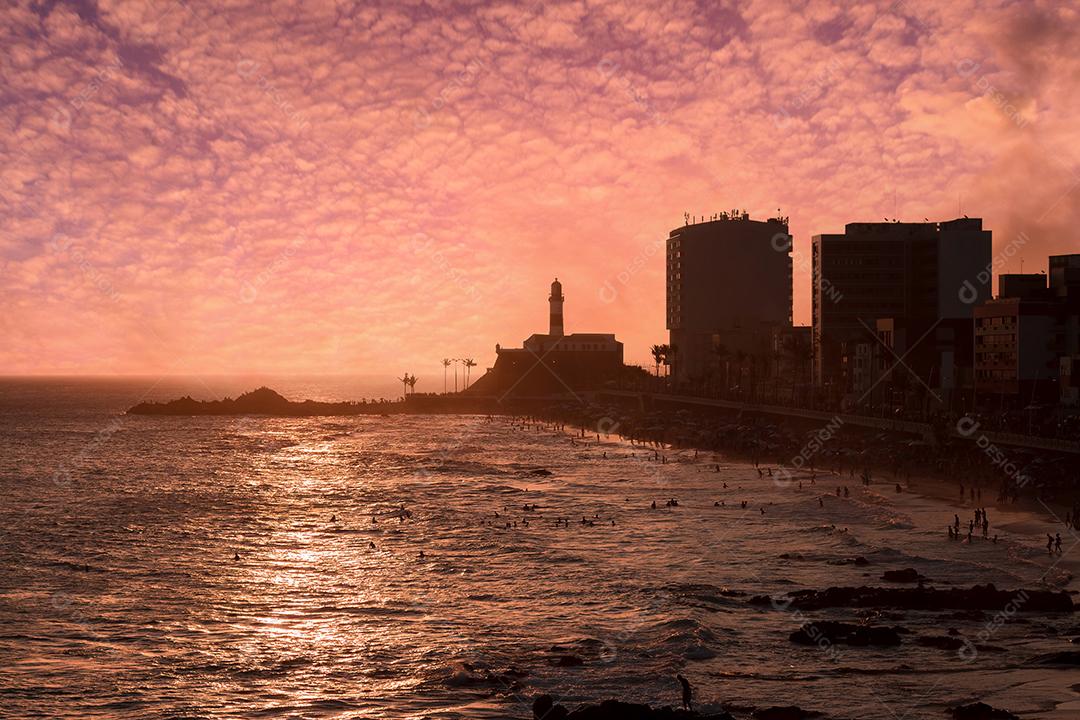 Vista do pôr do sol no bar da praia com o Farol da Barra ao fundo