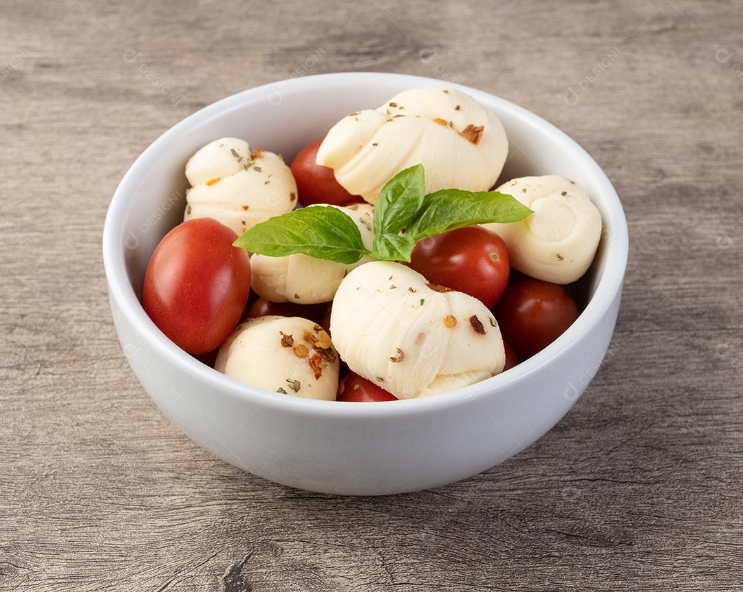 Nozinho ou Knot mussarela, típico queijo branco artesanal brasileiro com temperos, manjericão e tomate cereja.