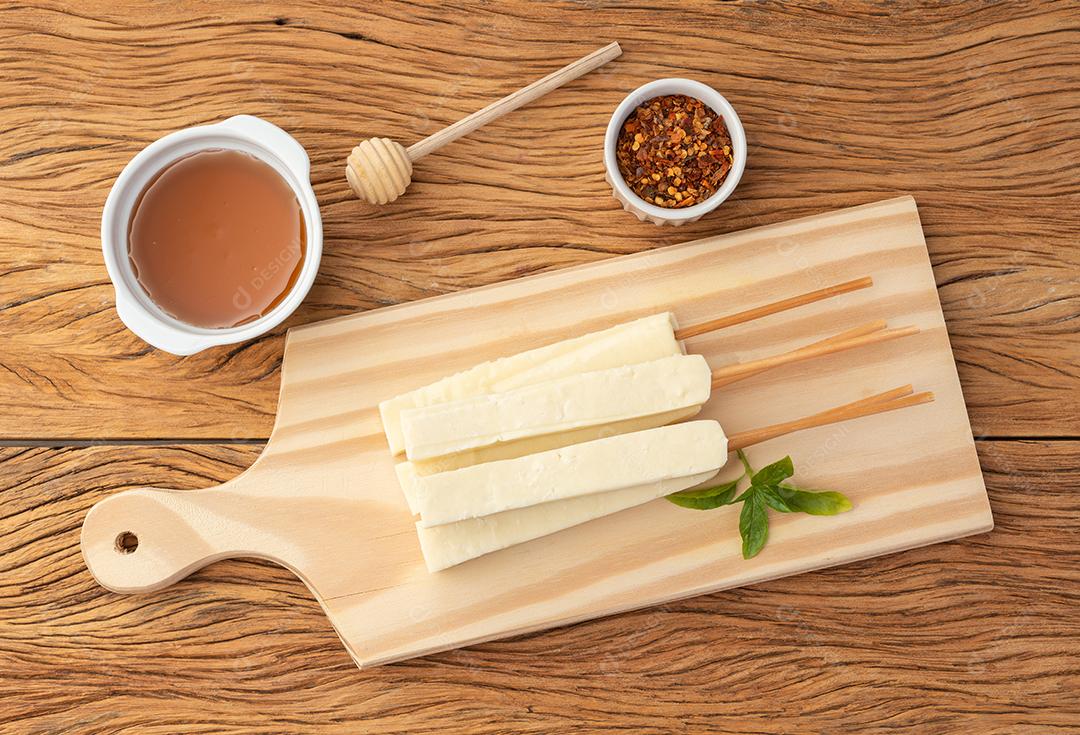 Renegar ou queijo Coalho em uma tábua de madeira com xarope de açúcar e pimenta.