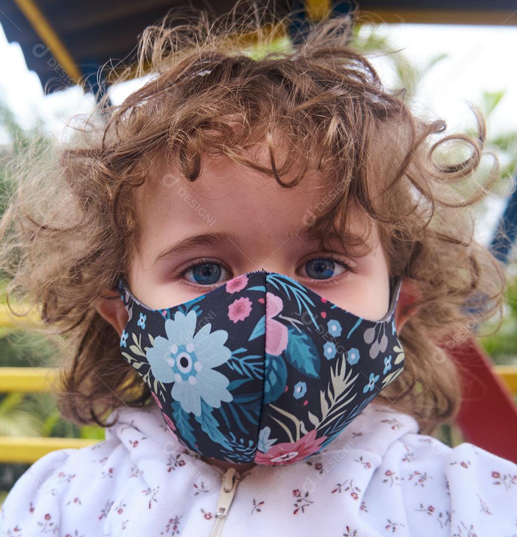 Perto de uma garotinha no playground com a máscara