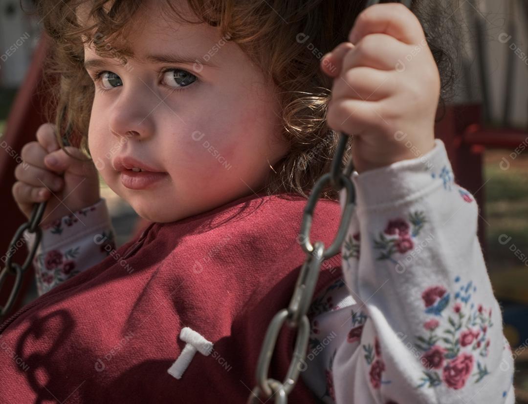 Menina brasileira no balanço ao ar livre