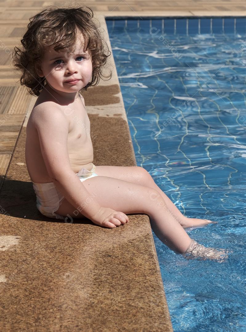 Menina brincando na piscina em um dia ensolarado