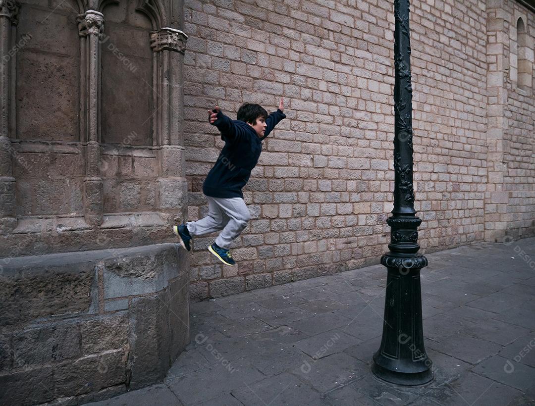 Garoto fazendo parkour nas ruas de barcelona.