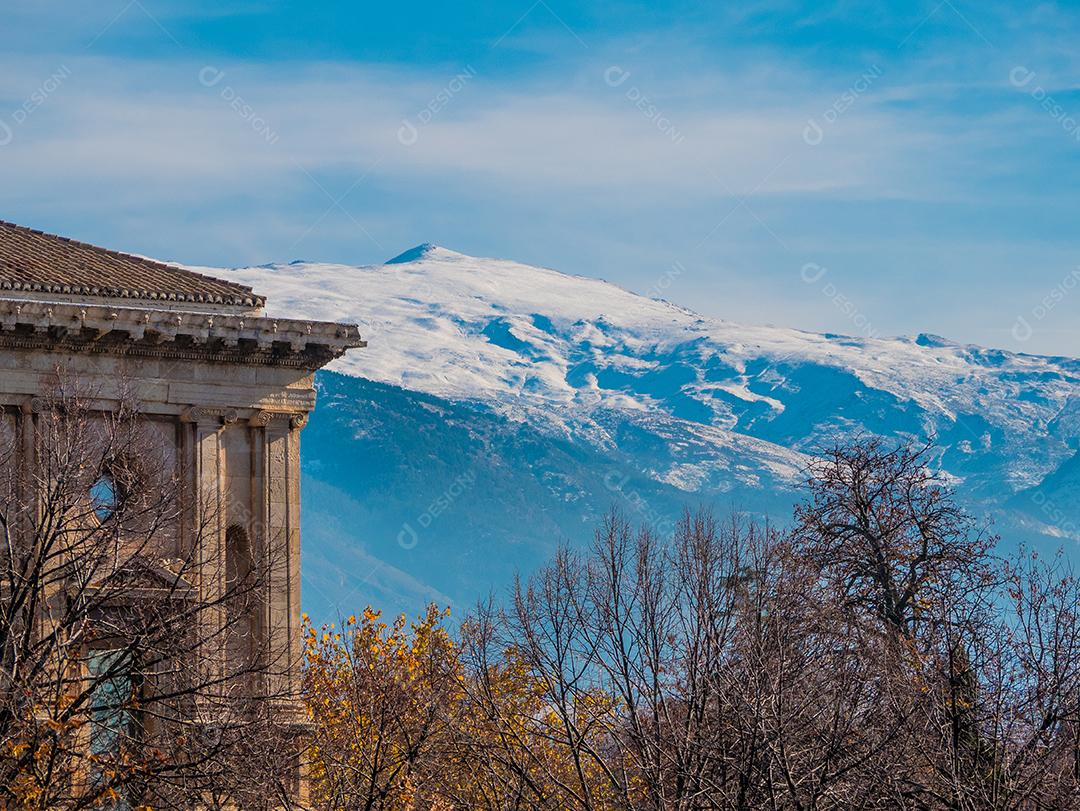 Construção Antiga com árvores secas com serra nevada em segundo plano