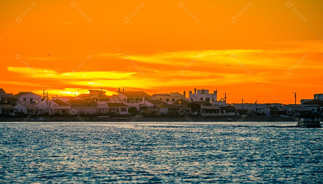 Pôr do sol na praia com sol no céu.