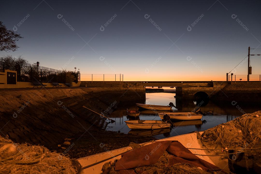 Foto de longa exposição do cais de Faro ao pôr do sol.