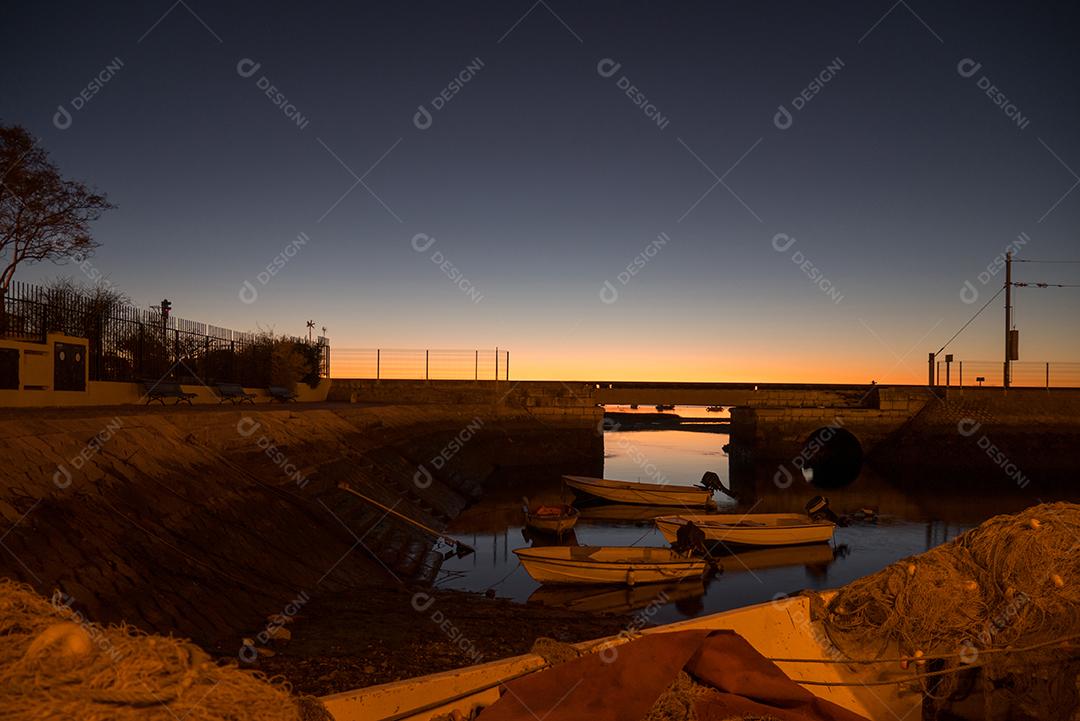 Foto de longa exposição do cais de Faro ao pôr do sol.