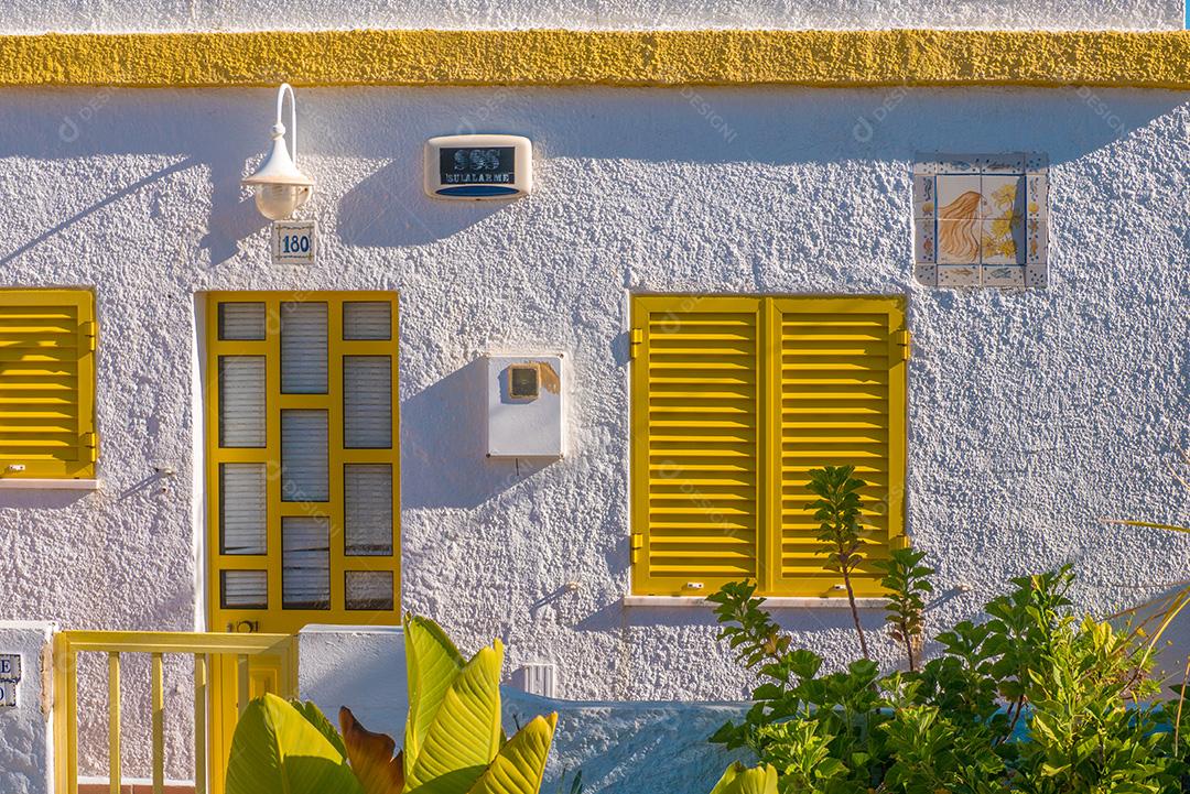Fachada da casa com janelas amarelas