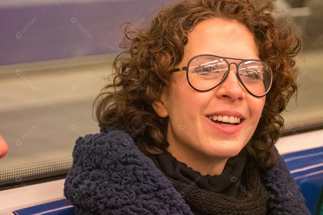 Mulher de cabelo encaracolado posando no metrô.