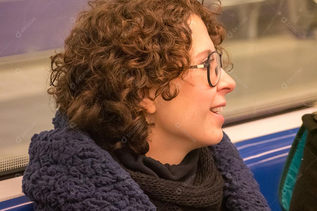 Mulher de cabelo encaracolado posando no metrô.