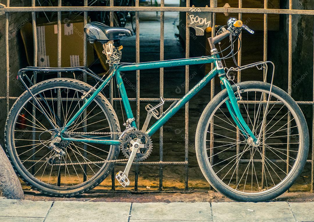 Bicicleta parada em frente a um portão.