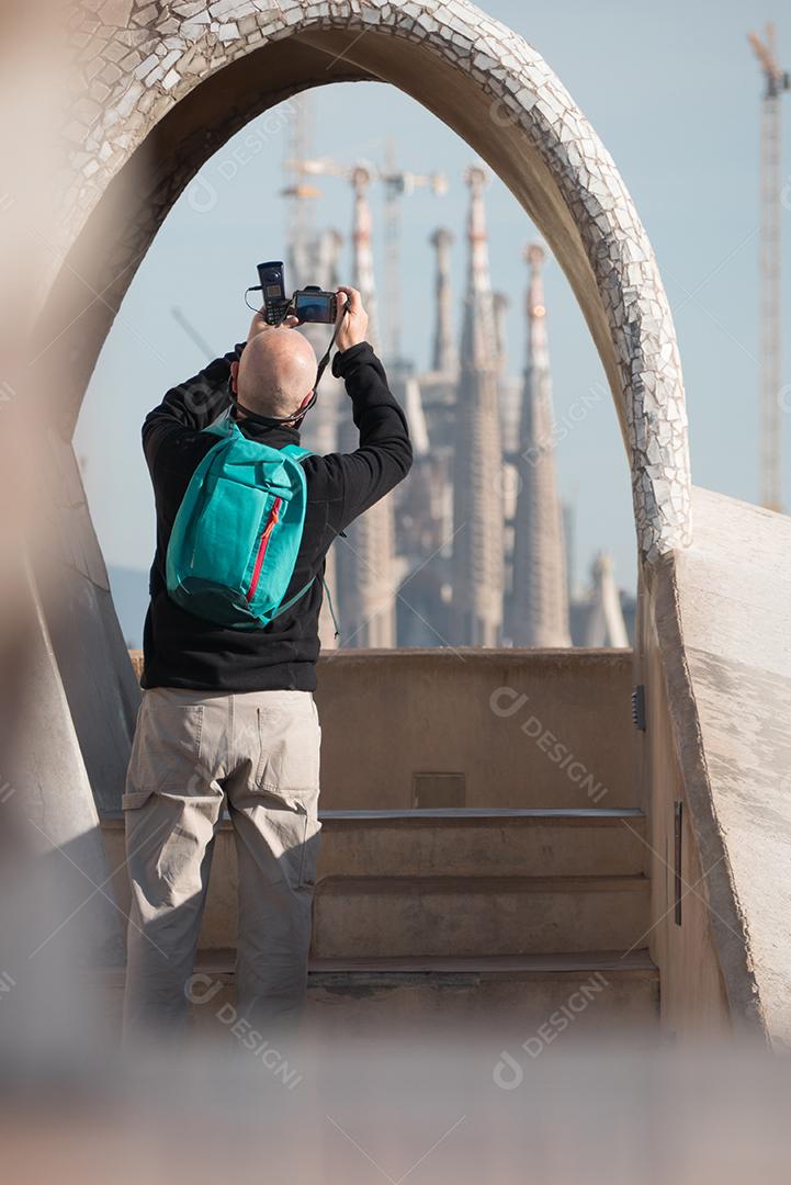 Man taking the Sagrada Familia Cathedral through an arch.