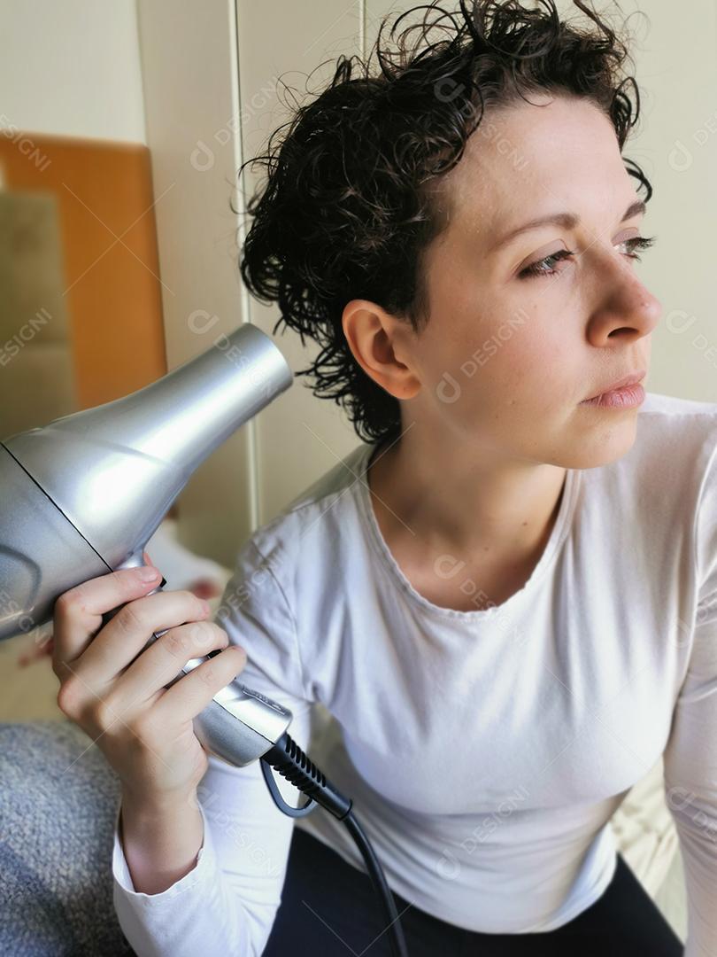 Moda mulher de cabelo encaracolado secando o cabelo dela.