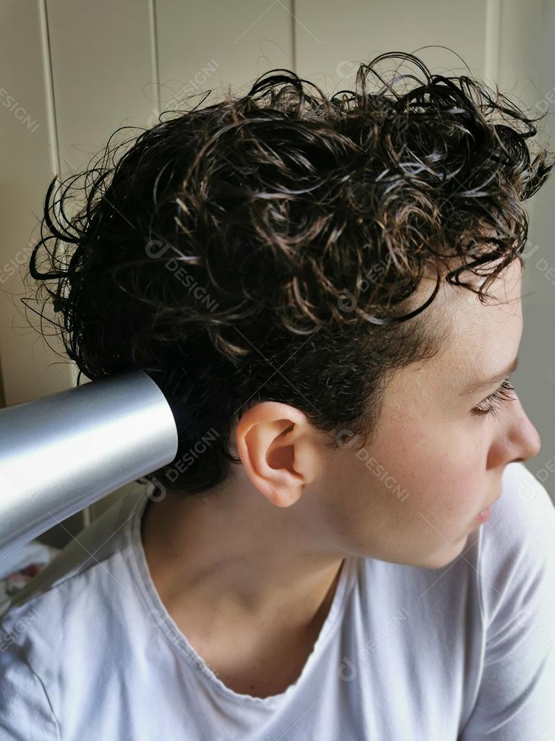 Moda mulher de cabelo encaracolado secando o cabelo dela.