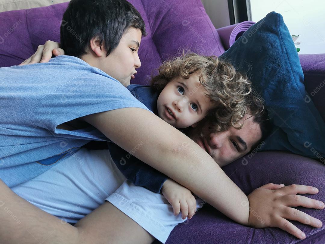 três verdadeiros irmãos brasileiros juntos no sofá.