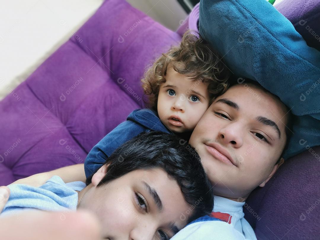 três verdadeiros irmãos brasileiros juntos no sofá.