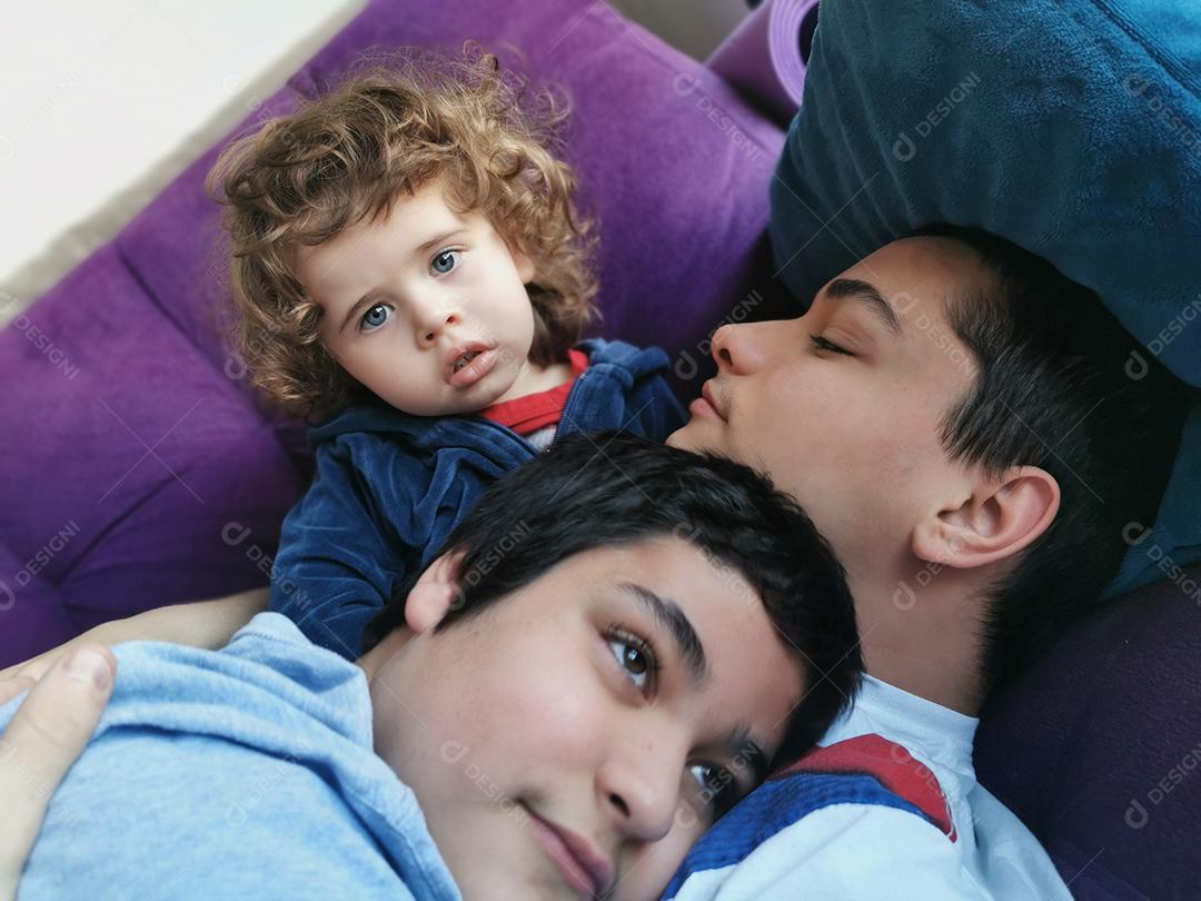 três verdadeiros irmãos brasileiros juntos no sofá.