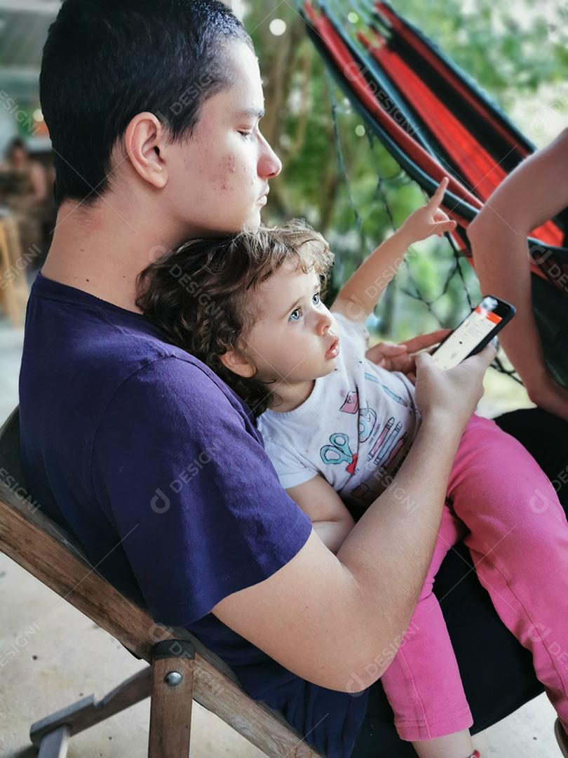 dois irmãos brasileiros juntos usando celular