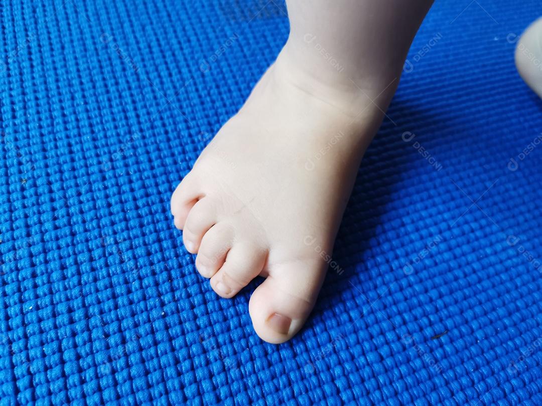 Pé de bebê sobre fundo azul.