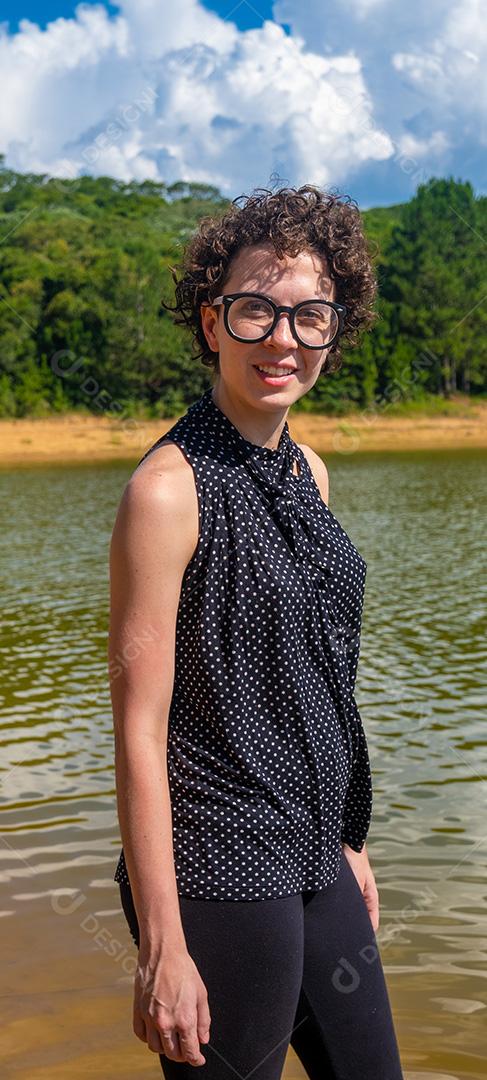 Linda jovem olhando para a câmera com fundo natural.