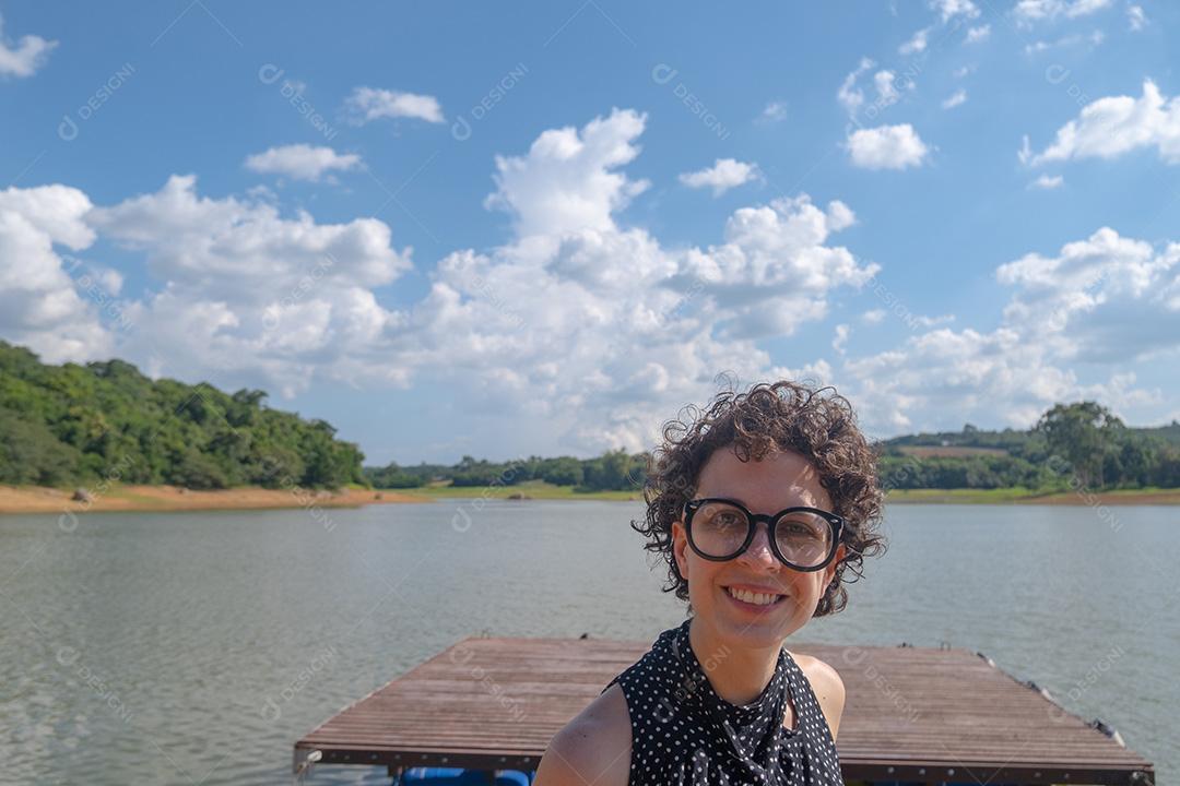 Linda jovem olhando para a câmera com fundo natural.