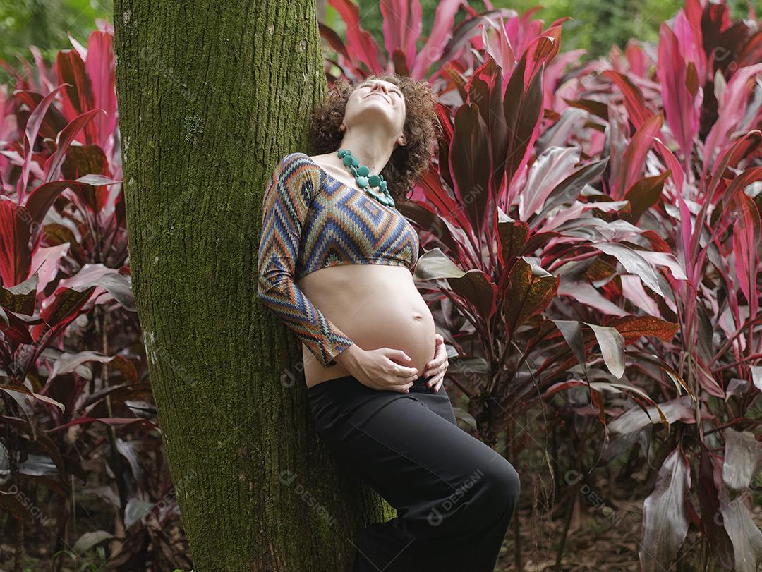 Perto da jovem grávida moderna ao ar livre.