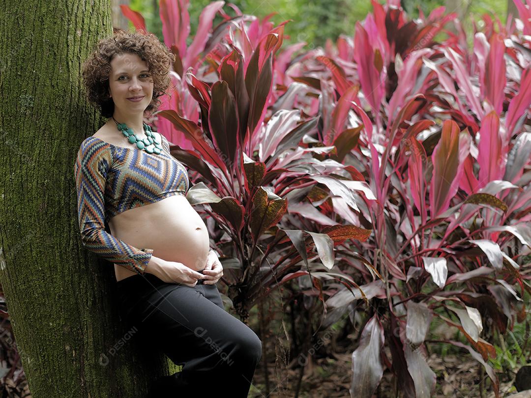 Perto da jovem grávida moderna ao ar livre.