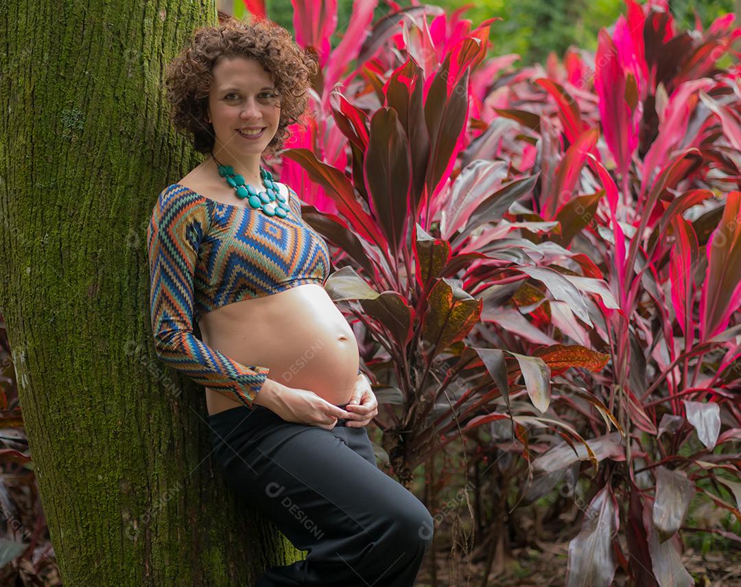 Perto da jovem grávida moderna ao ar livre.