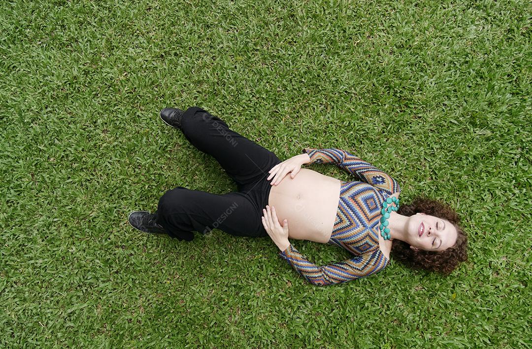 Vista superior da mulher grávida deitada na grama