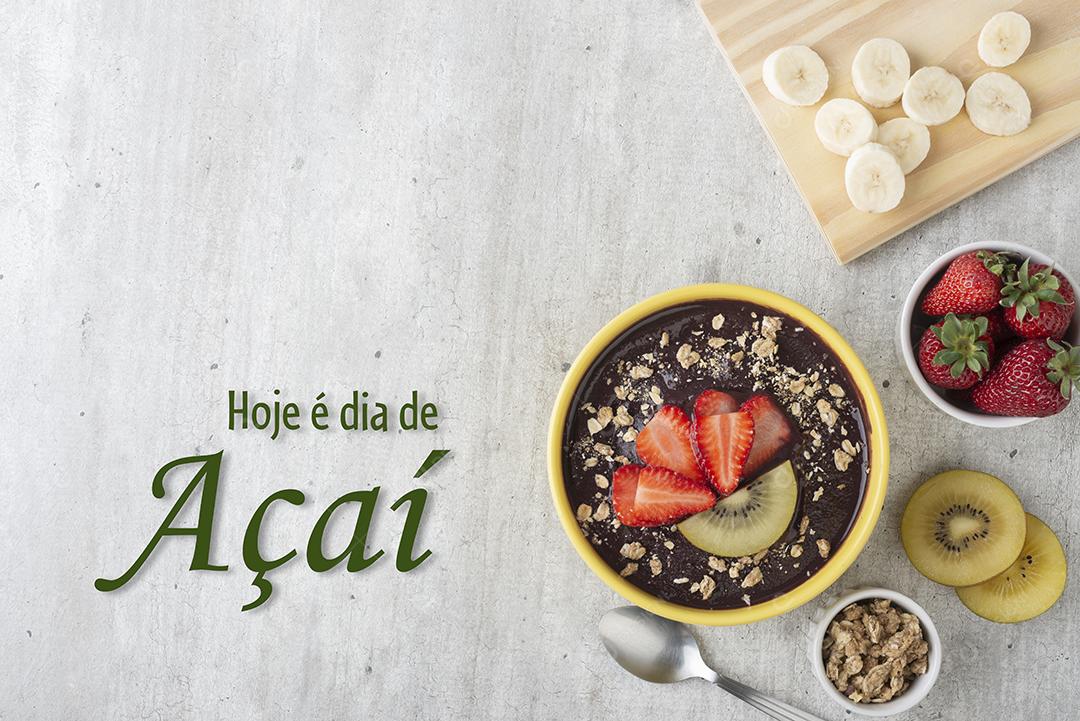 Tigela de açaí típica brasileira com frutas e muesli sobre fundo de madeira. Escrito Hoje é dia de açaí
